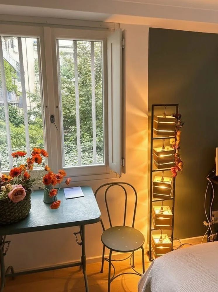 Tavolino con fiori e lampada accesa nella camera