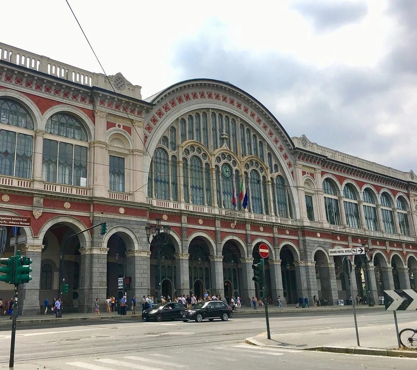 Facciata della stazione di Torino Porta Nuova con il grande arco vetrato centrale e i portici su corso Vittorio Emanuele II