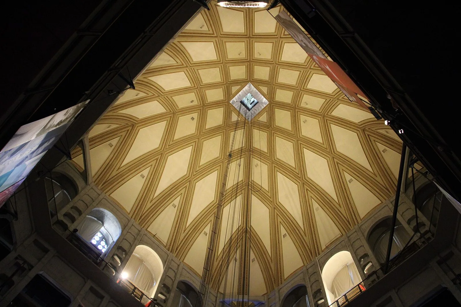 L'interno della cupola della Mole Antonelliana, sede del Museo Nazionale del Cinema, visto dal basso con i cassettoni dorati e i cavi che scendono dal centro della volta